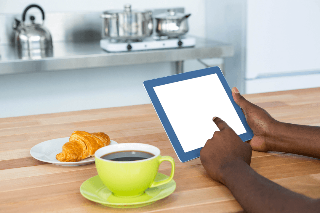 Man Using Digital Tablet at Kitchen Table with Transparent Screen