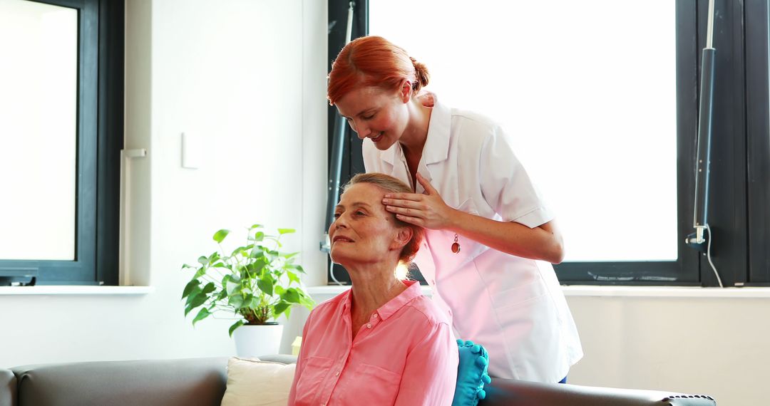 Healthcare Worker Massaging Relaxed Elderly Woman Near Window - Free Images, Stock Photos and Pictures on Pikwizard.com