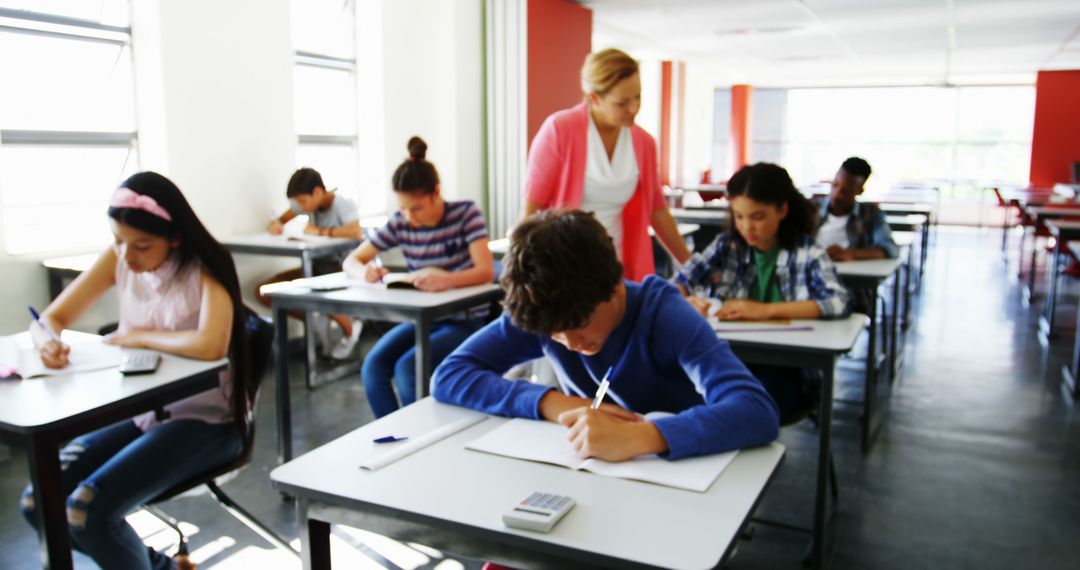 Students Taking Exam in Classroom with Teacher Supervising - Free Images, Stock Photos and Pictures on Pikwizard.com