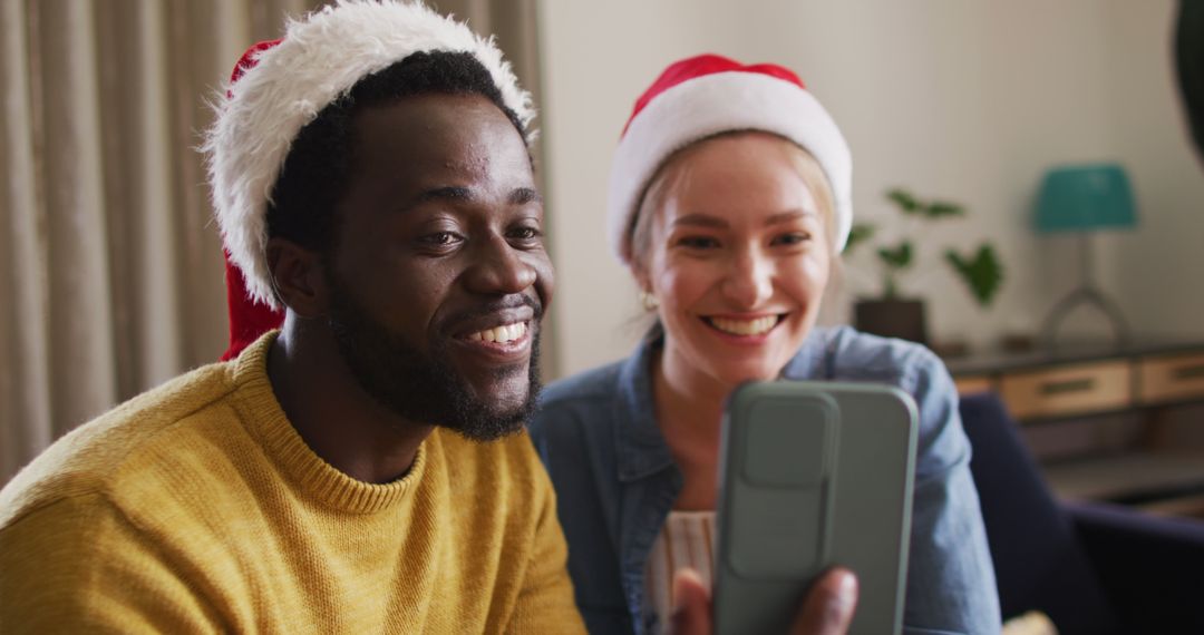 Smiling Couple in Santa Hats Taking a Selfie During Christmas Celebration - Free Images, Stock Photos and Pictures on Pikwizard.com