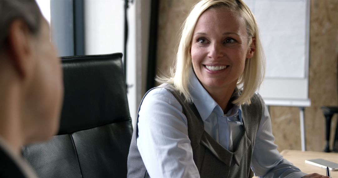 Smiling Businesswoman Engaging In Conversation During Office Meeting - Free Images, Stock Photos and Pictures on Pikwizard.com