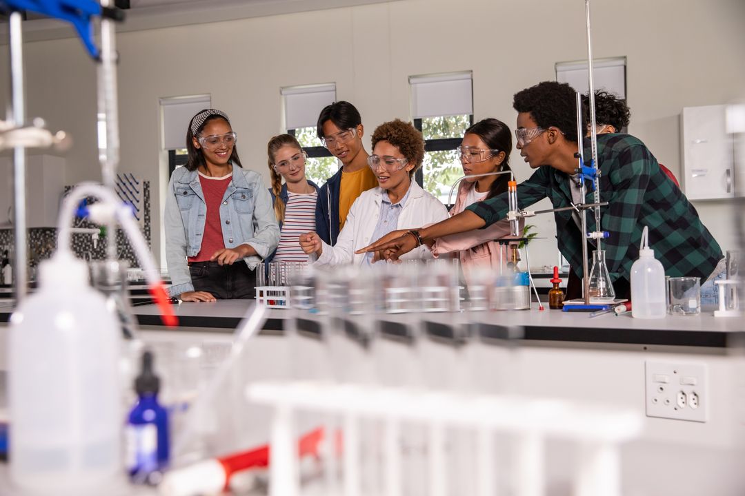 High school students and instructor conducting chemistry experiment in modern science lab