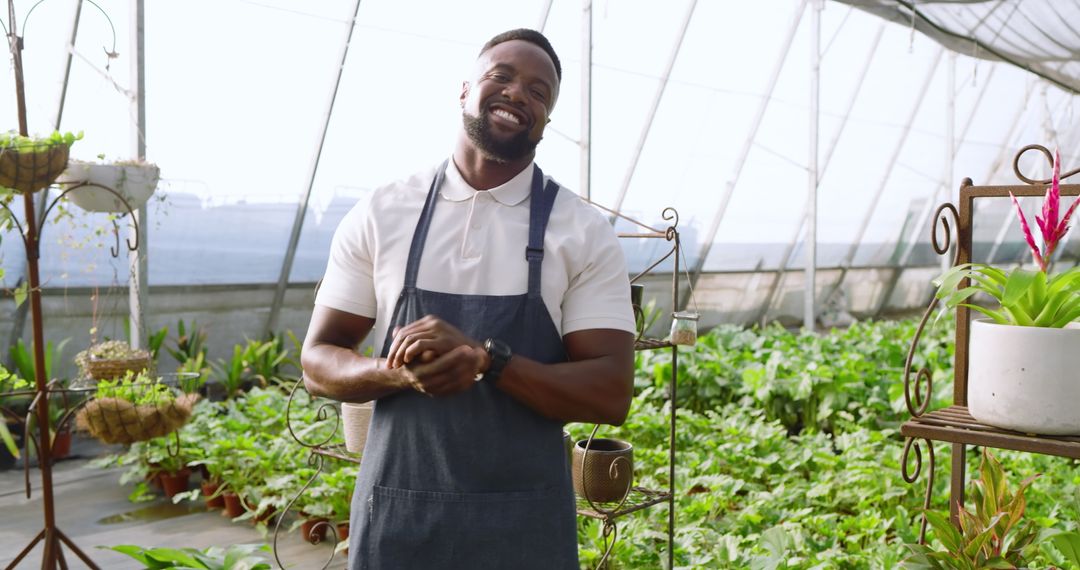 Smiling Gardener Tending Plants in a Sunny Greenhouse
