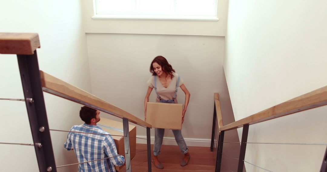 Couple Moving Boxes Down Staircase in New Home - Free Images, Stock Photos and Pictures on Pikwizard.com