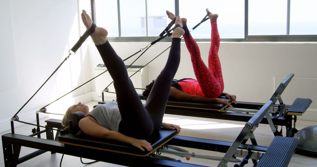 Women Performing Pilates Exercises on Reformer Machines - Free Images, Stock Photos and Pictures on Pikwizard.com