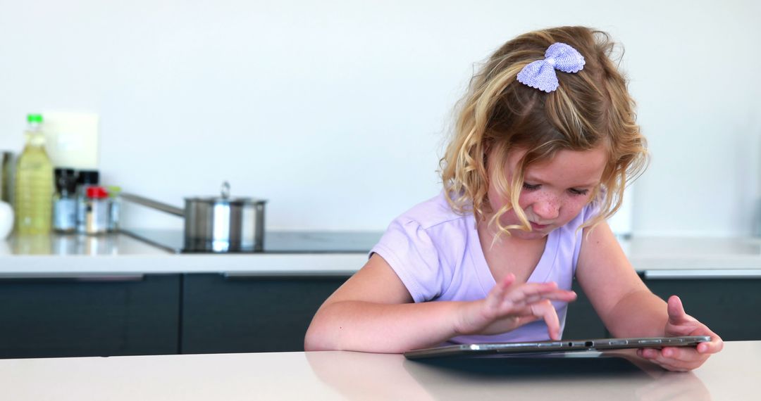 Young Girl Using Tablet at Kitchen Counter - Free Images, Stock Photos and Pictures on Pikwizard.com