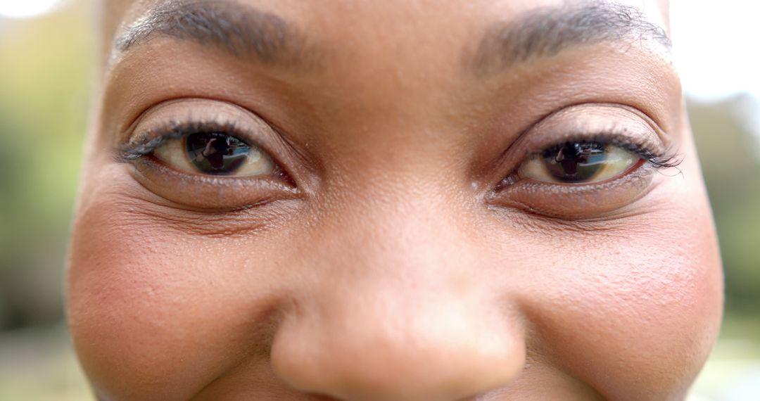 Eyes of happy african american woman standing and smiling in sunny garden - Free Images, Stock Photos and Pictures on Pikwizard.com