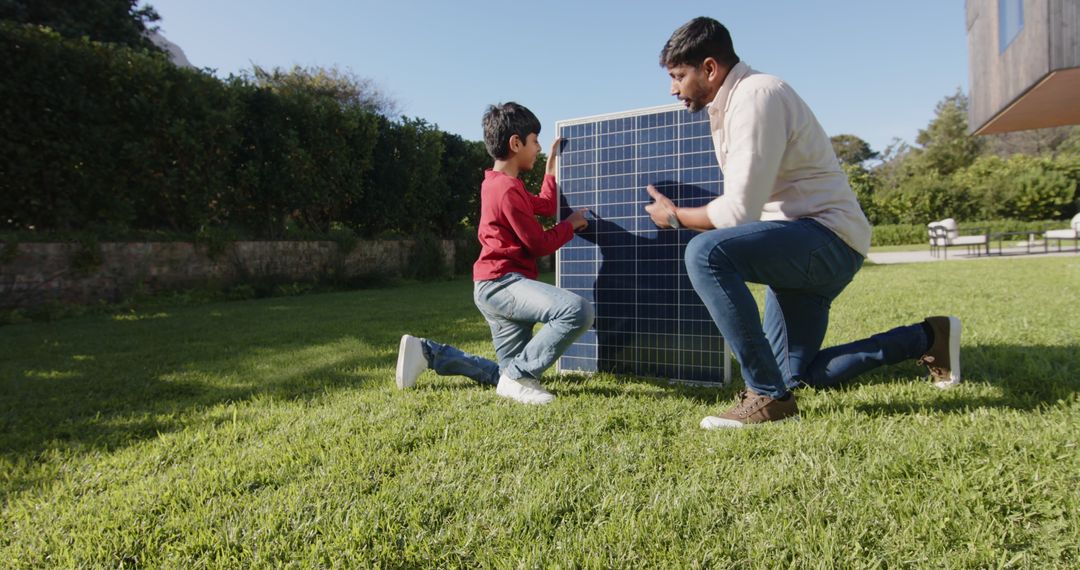 Father and Son Working with Solar Panel on Lawn During Sunny Day