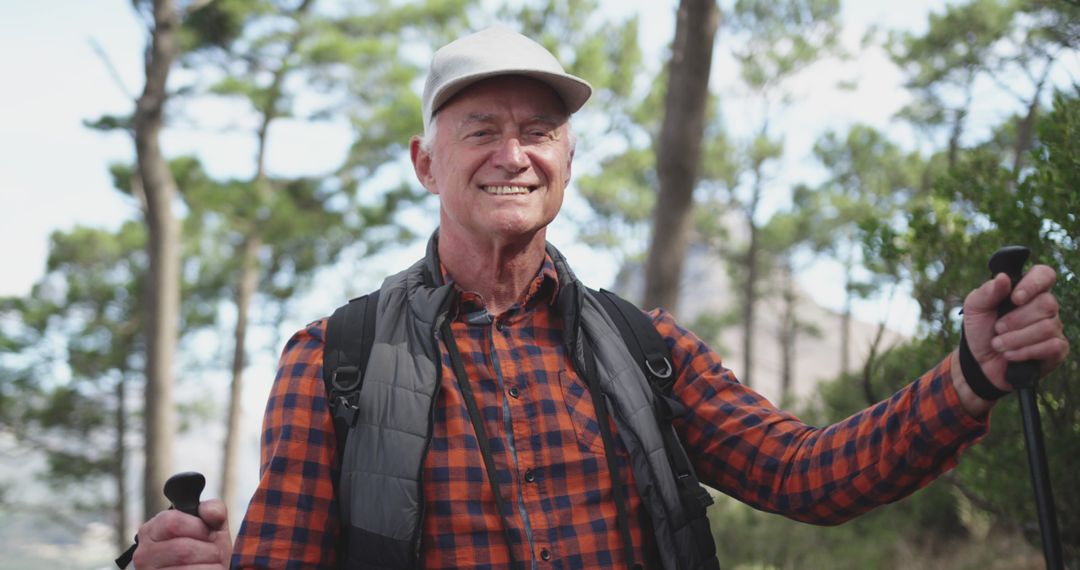 Portrait of happy senior caucasian man with cap in forest at sunny mountains - Free Images, Stock Photos and Pictures on Pikwizard.com