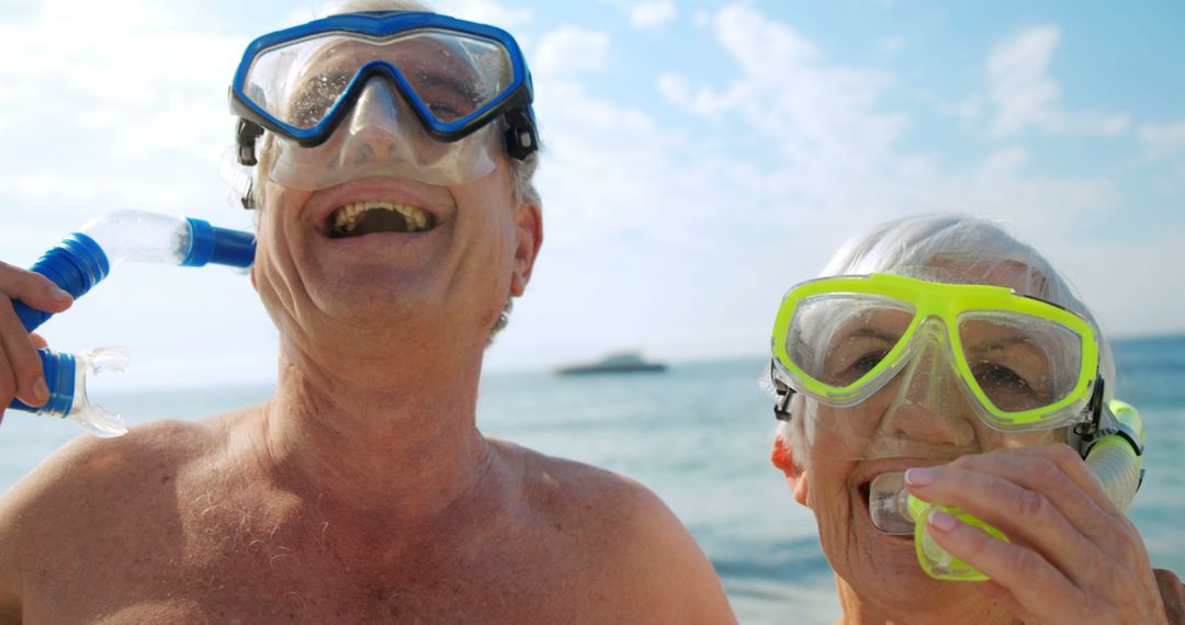 Senior Couple Smiling While Preparing for Snorkeling at Beach - Free Images, Stock Photos and Pictures on Pikwizard.com