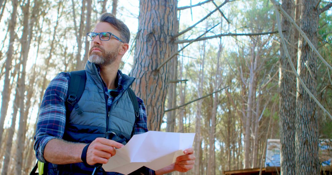 Man Navigating Forest with Map in Hand on Sunny Day - Free Images, Stock Photos and Pictures on Pikwizard.com