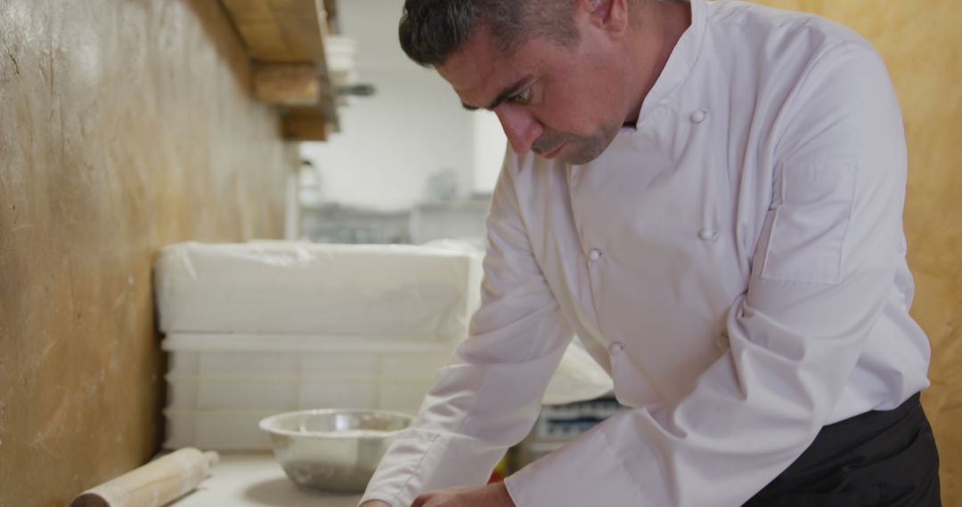 Experienced Chef Wearing White Uniform Preparing Dough in Rustic Kitchen - Free Images, Stock Photos and Pictures on Pikwizard.com