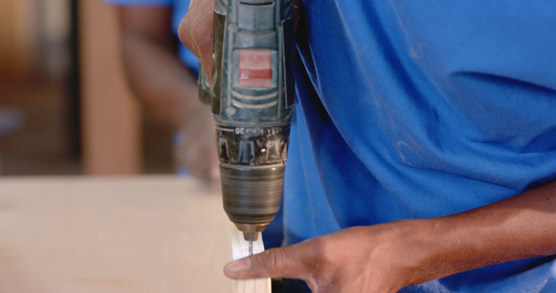 Hands Drilling Wood in Workshop Scene