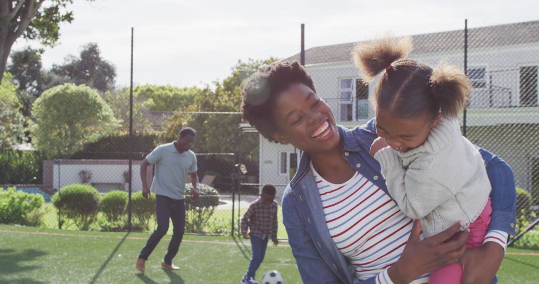 Portrait of happy african american family playing football in park - Free Images, Stock Photos and Pictures on Pikwizard.com