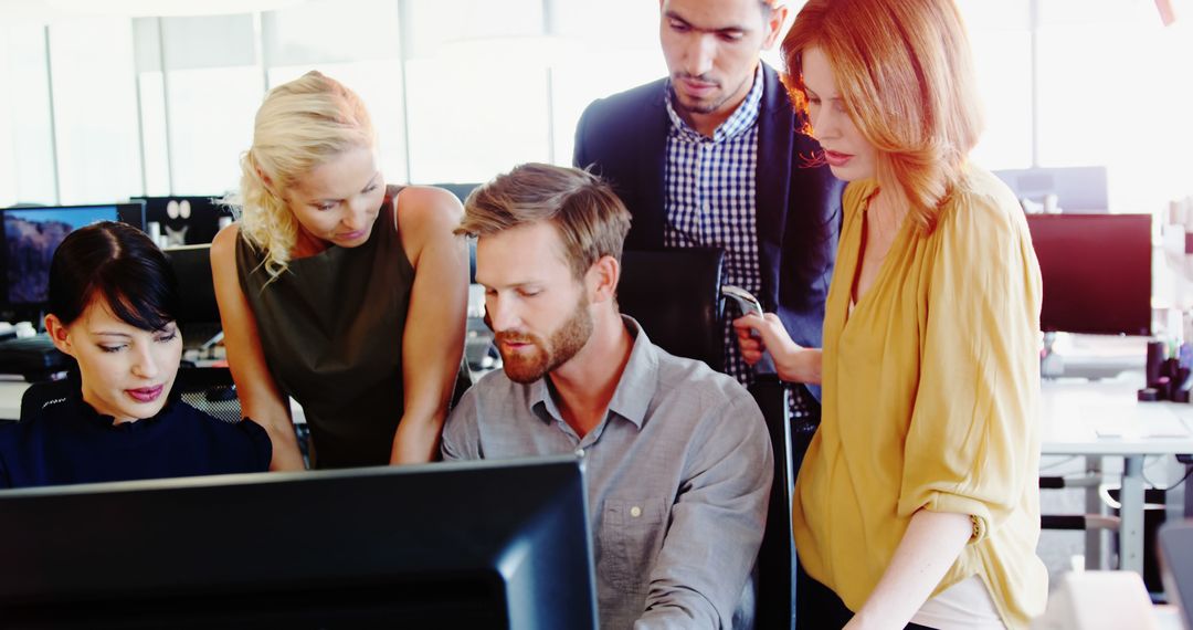 Diverse Team Collaborating on Computer in Modern Office