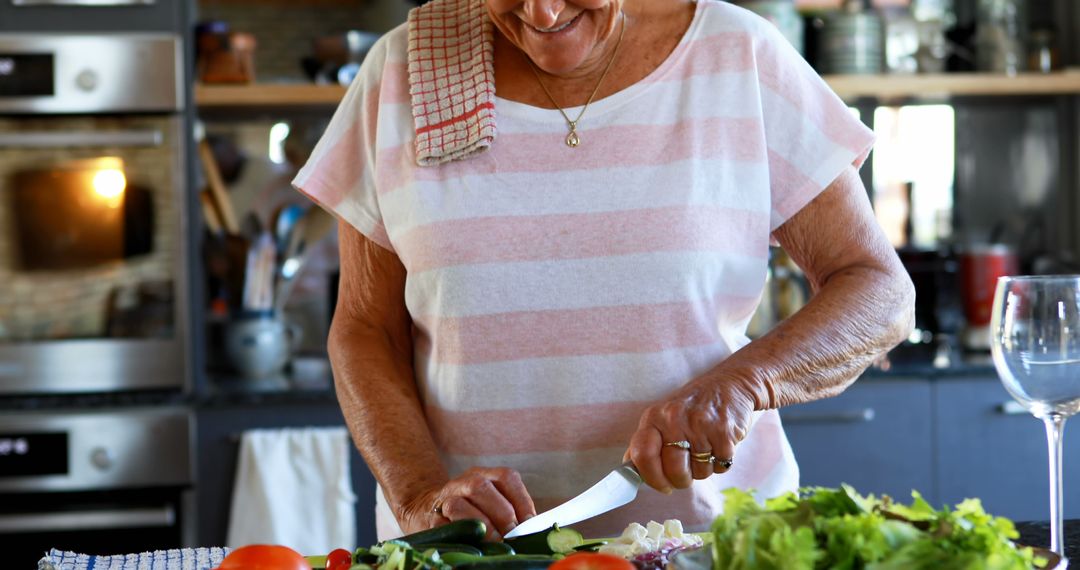 Elderly Woman Preparing Fresh Salad in Modern Kitchen - Free Images, Stock Photos and Pictures on Pikwizard.com