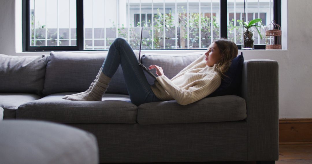 Young Woman Relaxing on Couch Using Laptop at Home - Free Images, Stock Photos and Pictures on Pikwizard.com