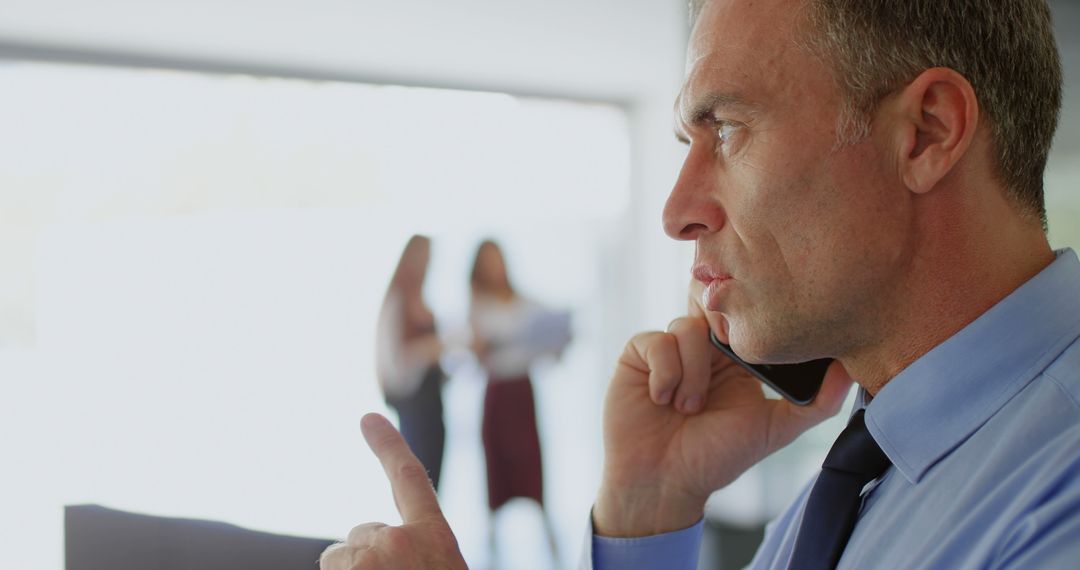 Serious Businessman Talking on Smartphone in Office - Free Images, Stock Photos and Pictures on Pikwizard.com