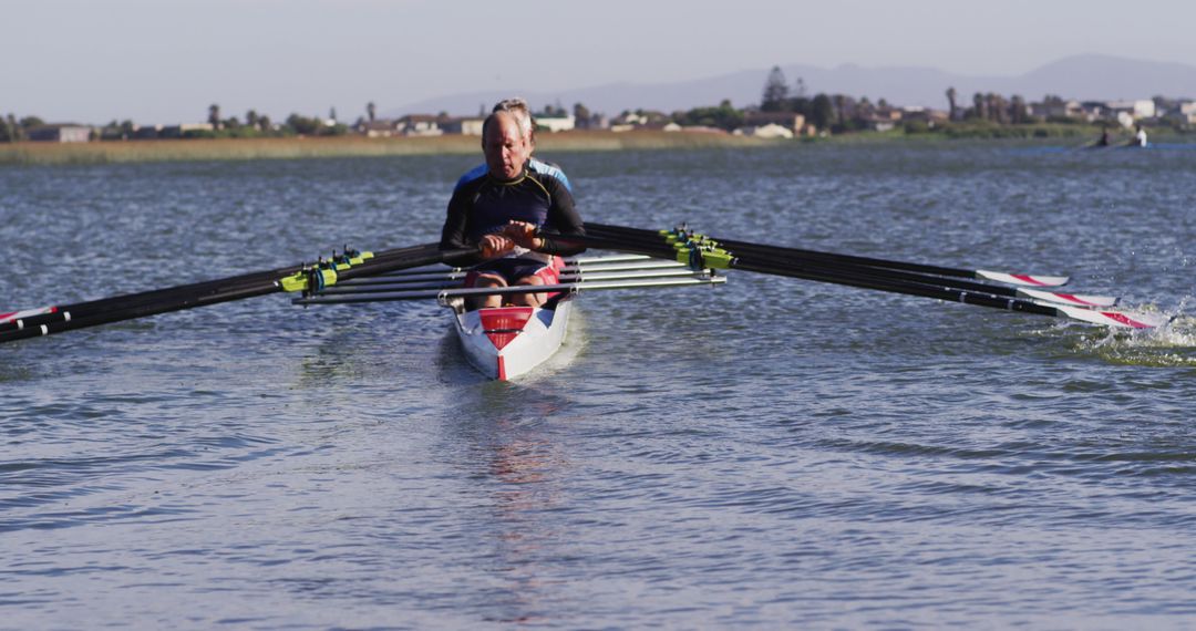 Male rower training in single scull on calm lake - Free Images, Stock Photos and Pictures on Pikwizard.com