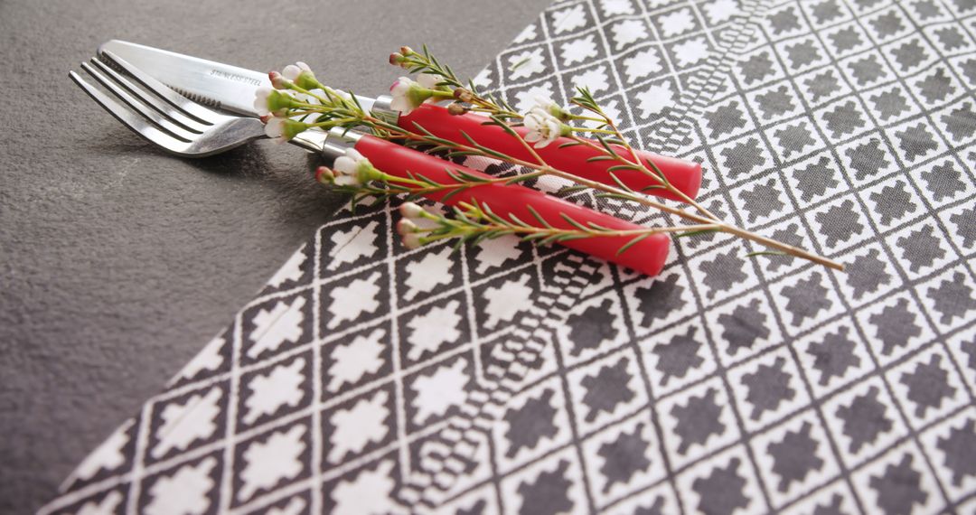 Stylish Table Setting with Forks and Red Handled Cutlery on Patterned Napkin - Free Images, Stock Photos and Pictures on Pikwizard.com