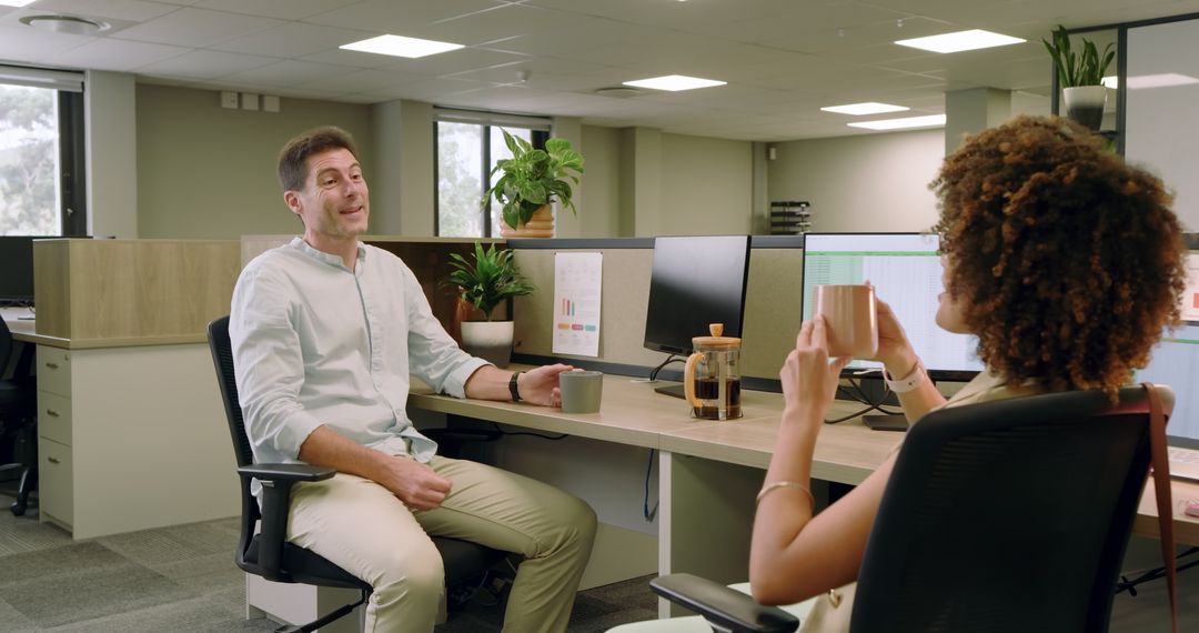 Colleagues Discussing Business Over Coffee in Modern Office