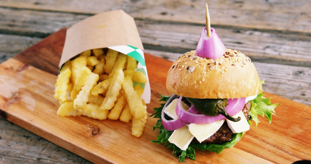 Gourmet Burger with Seasoned Fries on Wooden Board - Free Images, Stock Photos and Pictures on Pikwizard.com