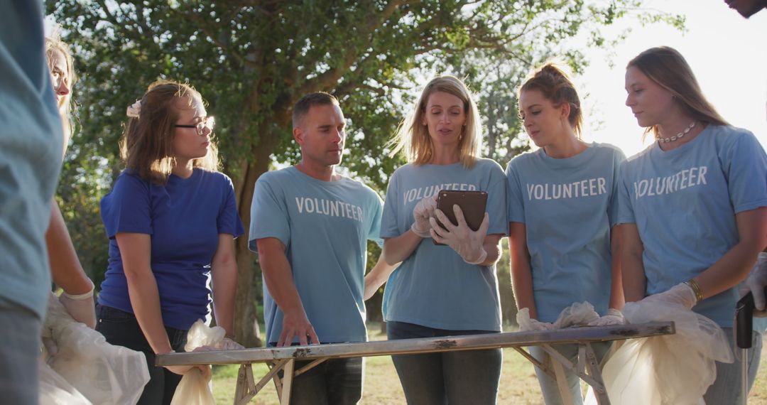 Group of Volunteers Discussing Project Holding Tablet - Free Images, Stock Photos and Pictures on Pikwizard.com