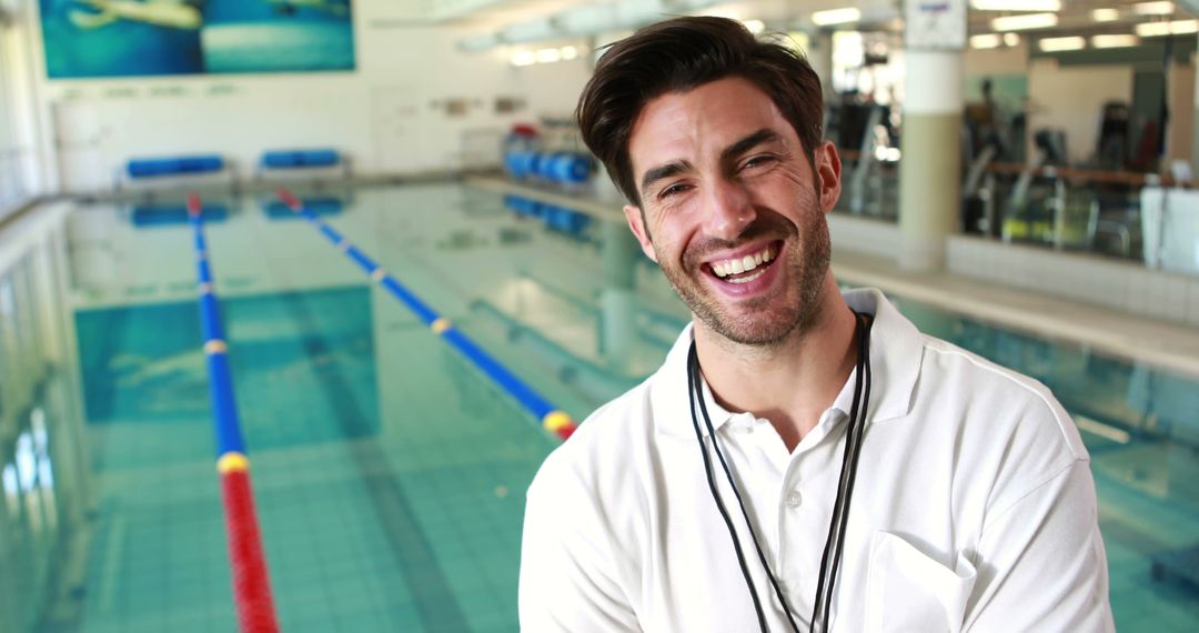 Cheerful Swim Coach Posing by Indoor Pool at Fitness Center - Free Images, Stock Photos and Pictures on Pikwizard.com