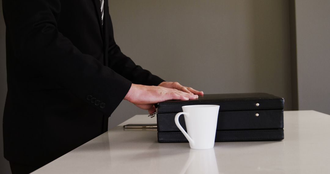 Businessperson with Briefcase and Coffee Mug in Office Setting - Free Images, Stock Photos and Pictures on Pikwizard.com