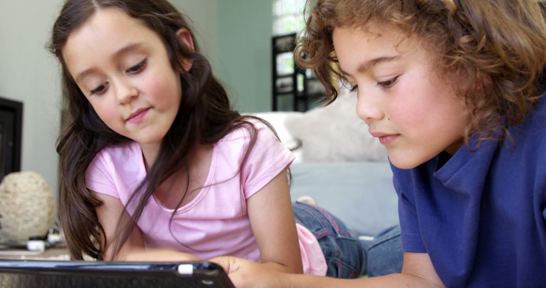 Two Children Using Tablet in Living Room - Free Images, Stock Photos and Pictures on Pikwizard.com