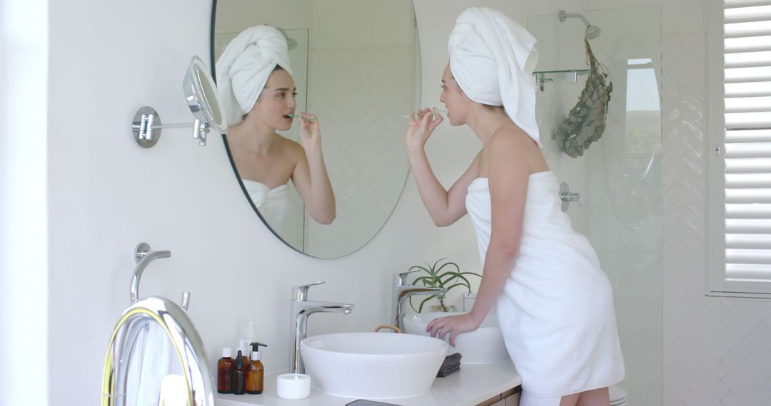 Woman Brushing Teeth in Modern Bathroom Wrapped in Towel - Free Images, Stock Photos and Pictures on Pikwizard.com