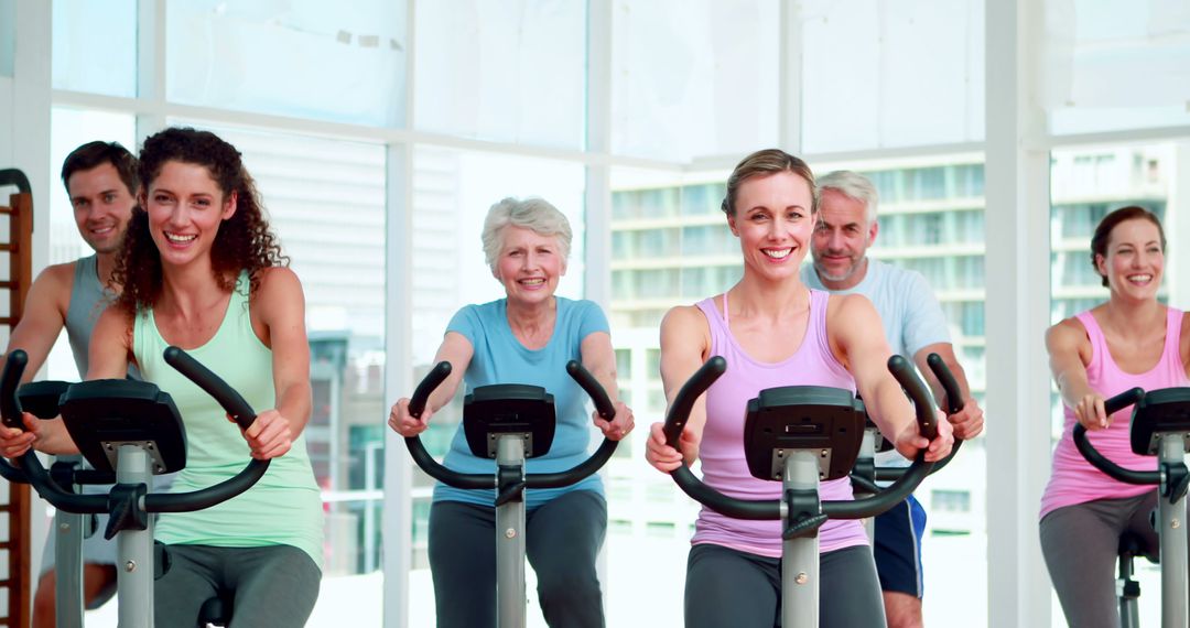 Diverse Group Smiling While Exercising on Stationary Bikes - Free Images, Stock Photos and Pictures on Pikwizard.com