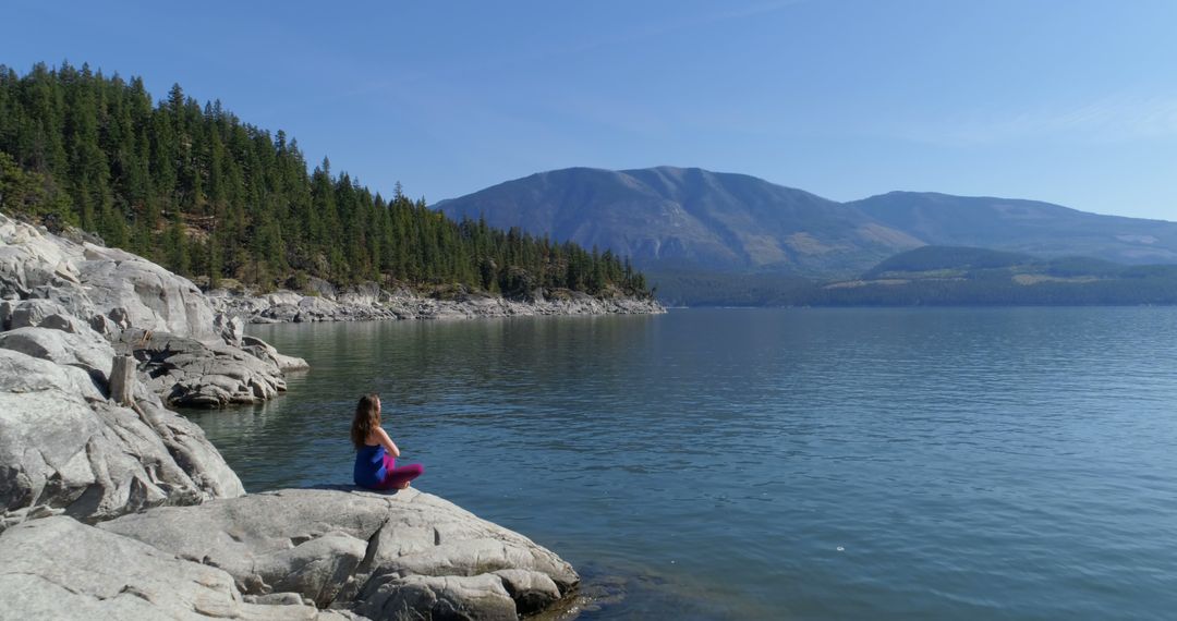 Woman Meditating by Serene Mountain Lake - Free Images, Stock Photos and Pictures on Pikwizard.com