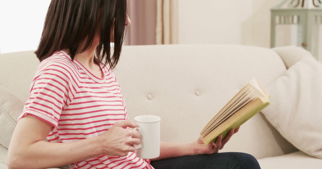 Woman Reading Book on Couch While Drinking Coffee - Free Images, Stock Photos and Pictures on Pikwizard.com