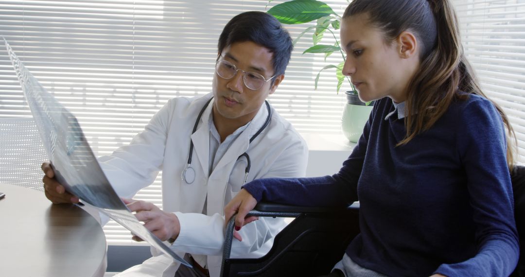 Doctor Consulting Young Female Patient Reviewing X-ray - Free Images, Stock Photos and Pictures on Pikwizard.com