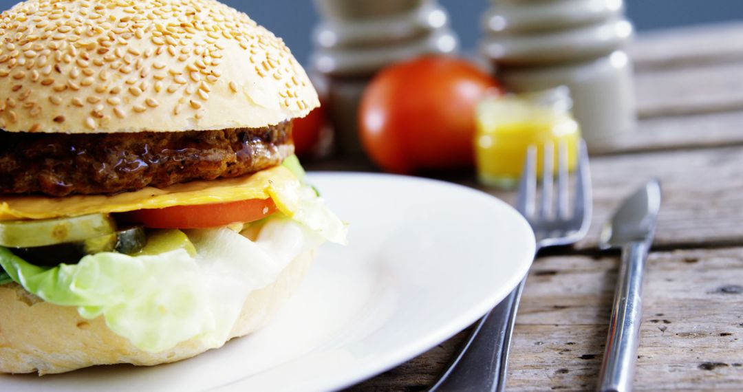 Cheeseburger with Fresh Vegetables on Rustic Wooden Table