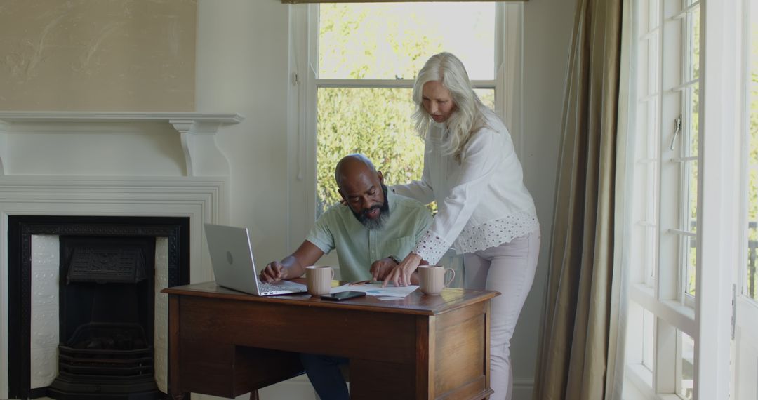 Senior Couple Collaborating Over Laptop at Home