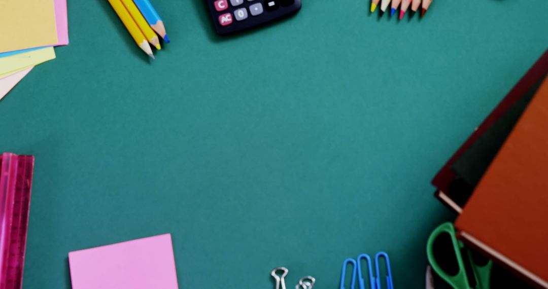 School Supplies and Electronics on Green Desk Background