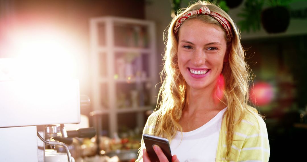 Young Woman Smiling and Using Smartphone at Coffee Shop - Free Images, Stock Photos and Pictures on Pikwizard.com