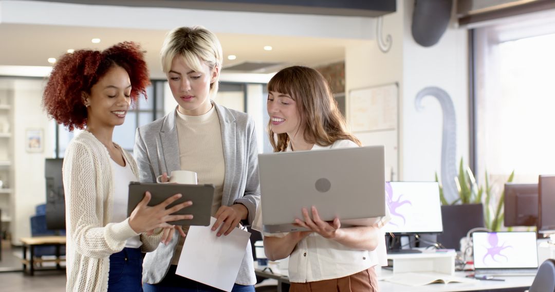 Diverse Female Team Collaborating with Technology in Modern Office