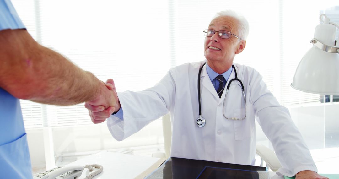 Senior Doctor Handshaking with Patient in Medical Office - Free Images, Stock Photos and Pictures on Pikwizard.com