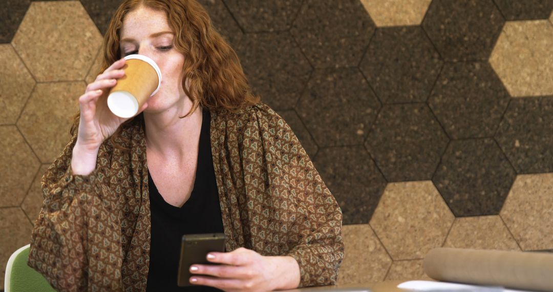 Woman Drinking Coffee And Using Smartphone In Modern Workspace - Free Images, Stock Photos and Pictures on Pikwizard.com