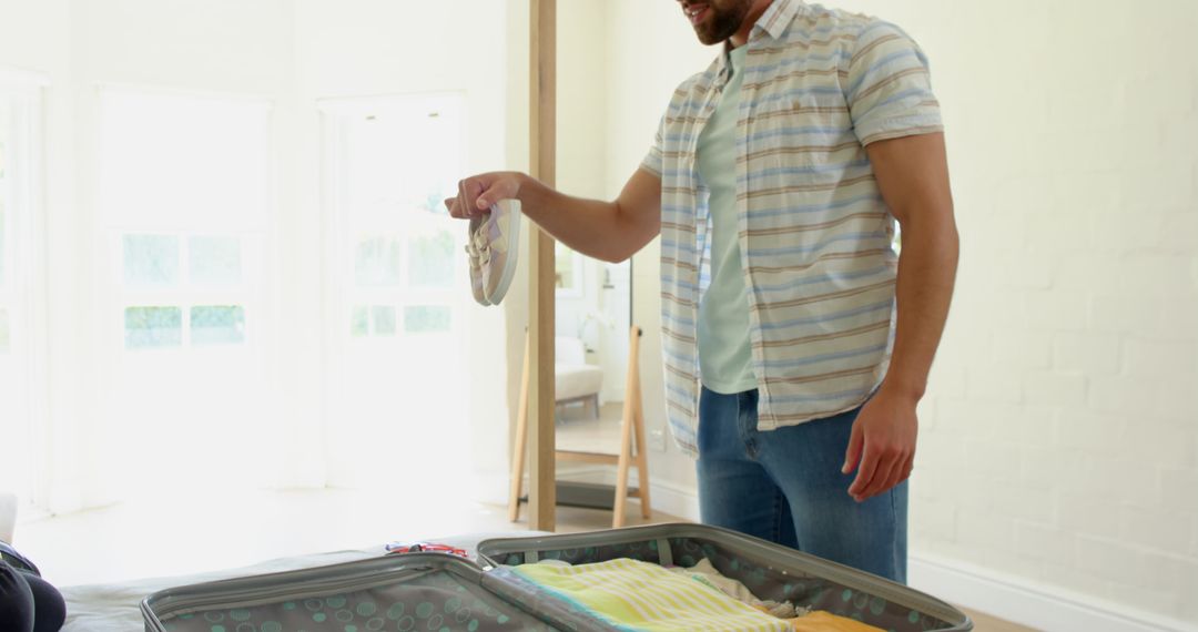 Man Packing Suitcase in Sunlit Bedroom for Travel Adventures