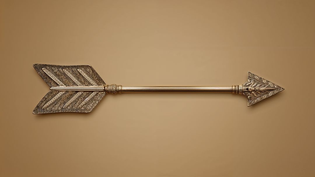 Ornate Metal Arrow with Intricate Engravings on Tan Backdrop