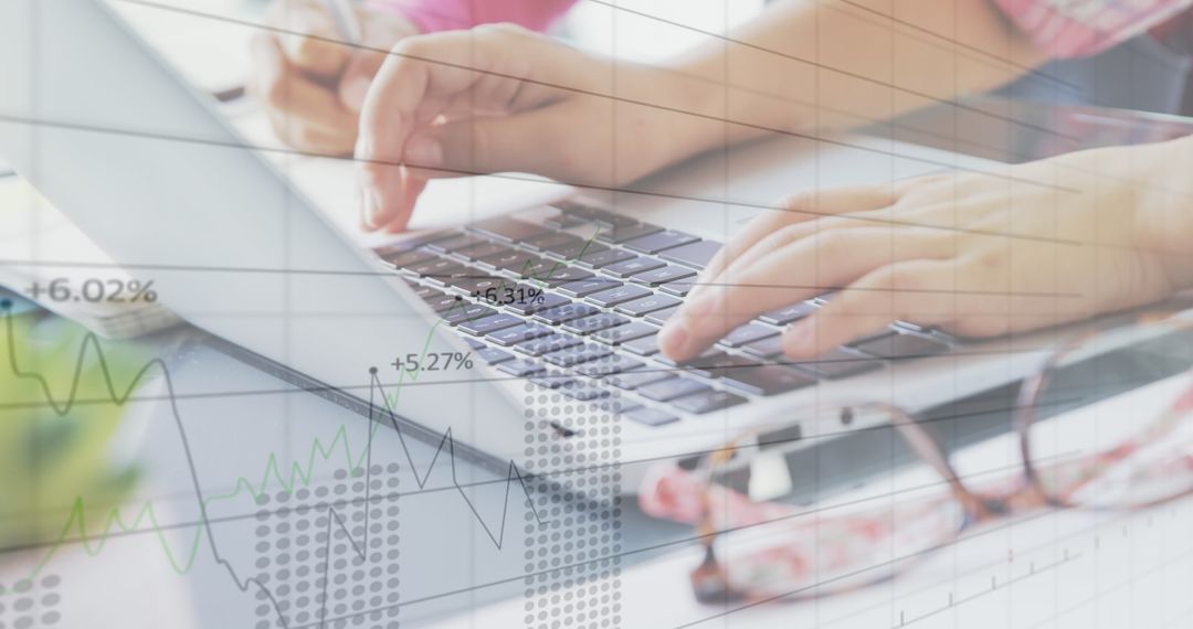 Hands Typing on Laptop with Financial Data Overlay
