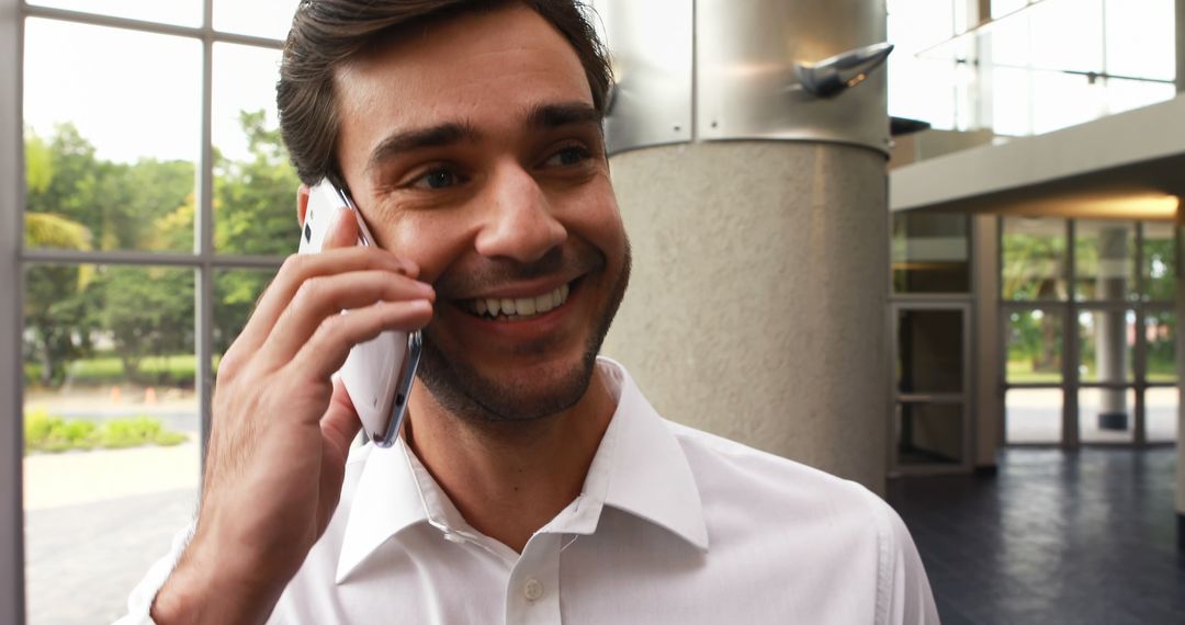 Smiling Man on Phone in Modern Office