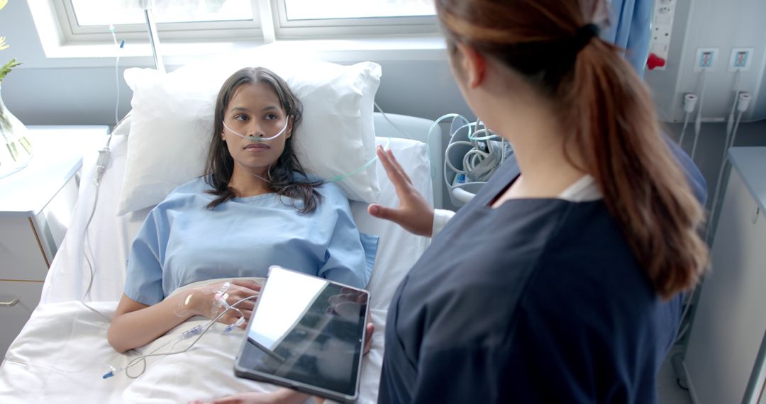 Female Patient in Hospital Bed Consulted by Doctor Using Digital Tablet