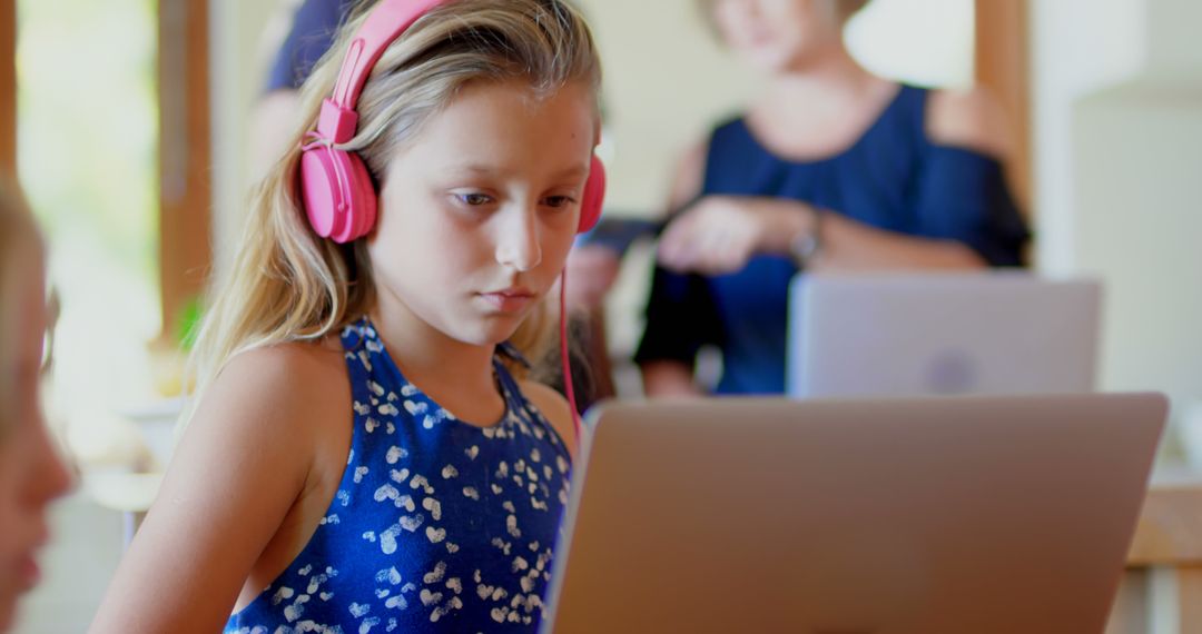 Focused Young Girl Wearing Headphones Using Laptop for E-Learning - Free Images, Stock Photos and Pictures on Pikwizard.com