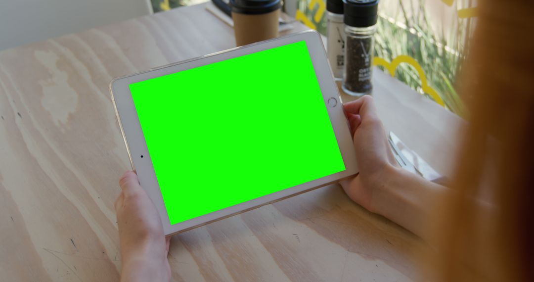 Person Using Digital Tablet with Green Screen at Cafe - Free Images, Stock Photos and Pictures on Pikwizard.com