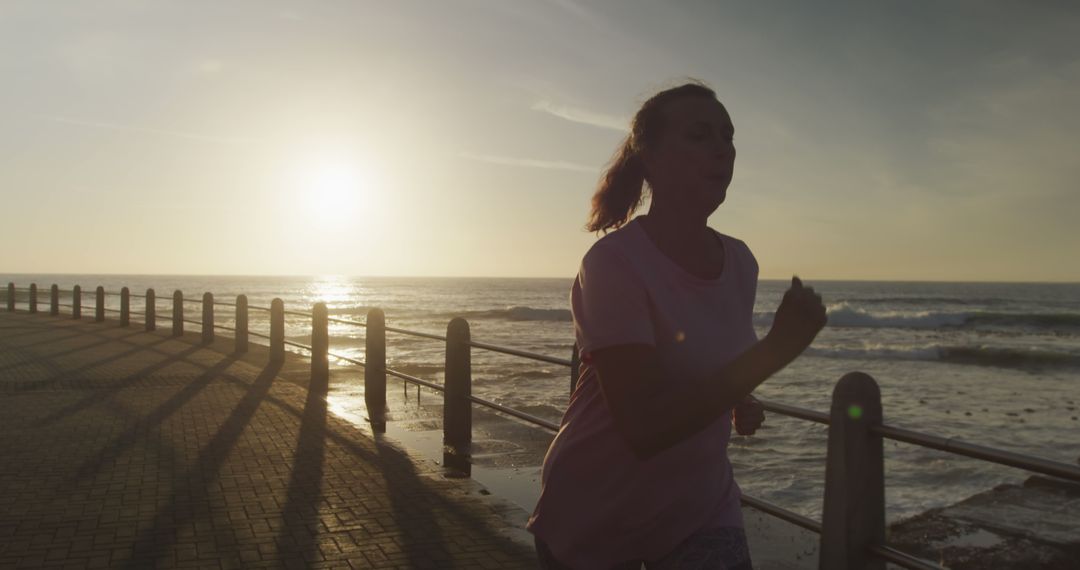 Woman Jogging Along Seaside Promenade at Sunrise - Free Images, Stock Photos and Pictures on Pikwizard.com